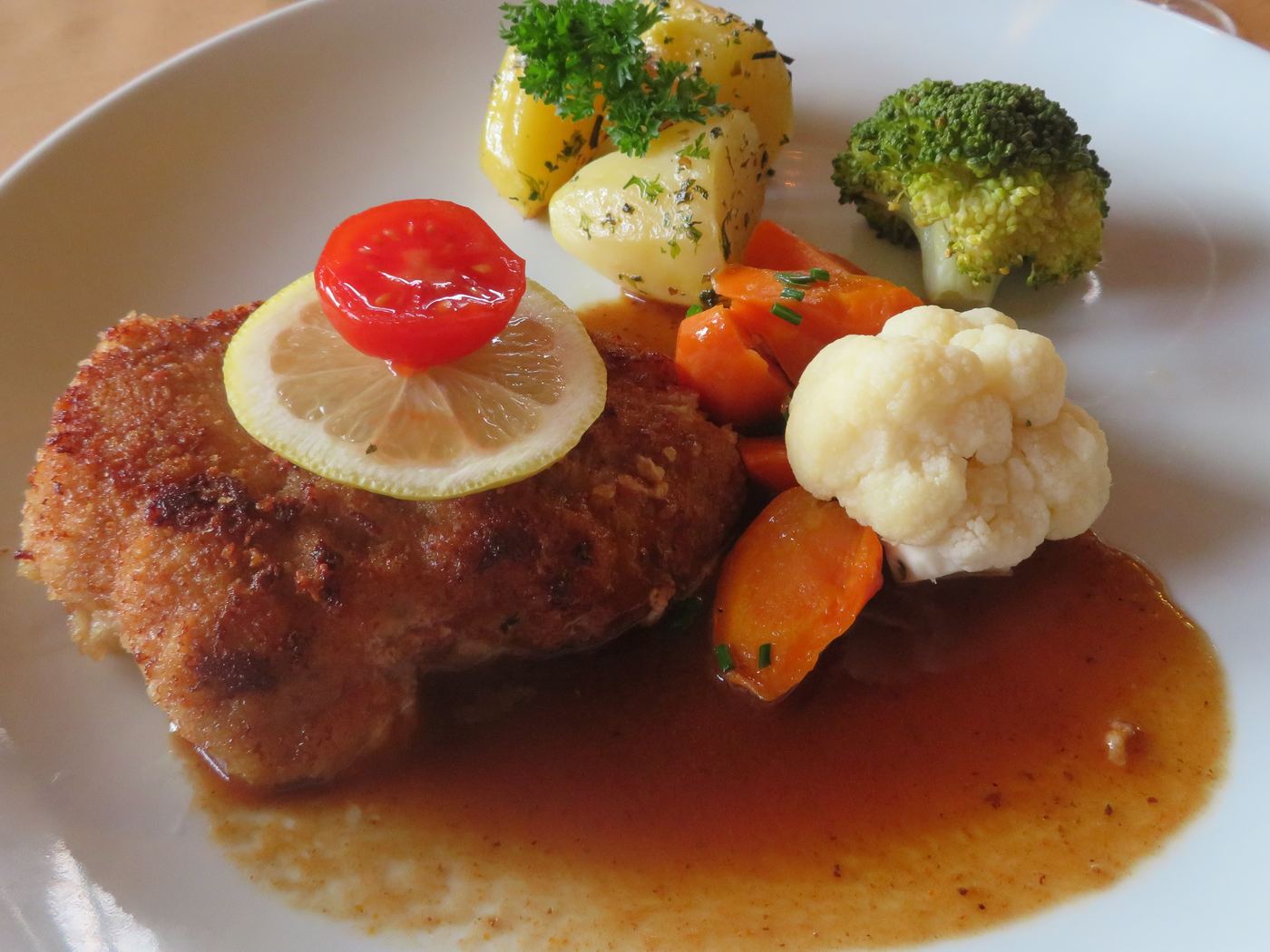 Paniertes Cordon bleu mit Sauce, Kartoffeln und Gemüse